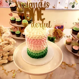 a cake and cupcakes on a table