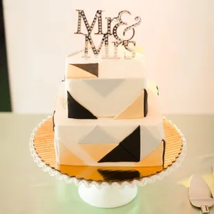a three tiered cake with the word mr and mrs on top