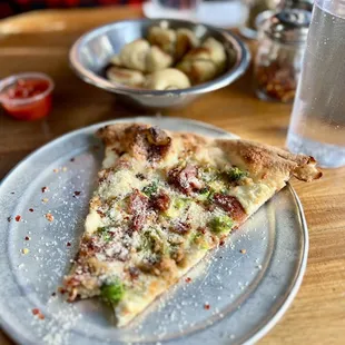 Meat pizza slice. I could do without the broccoli on it.