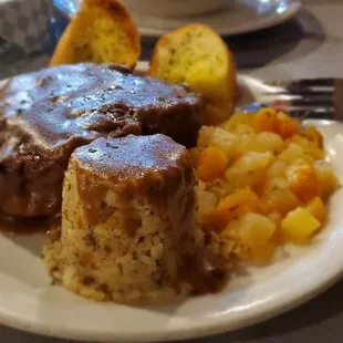 Smothered pork chop, dirty rice, fruit compote on the side to balance out the meal.