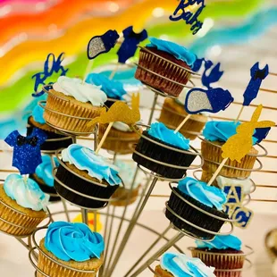 a display of cupcakes with blue frosting