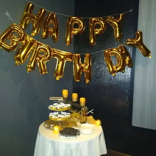 a table with a cake and balloons