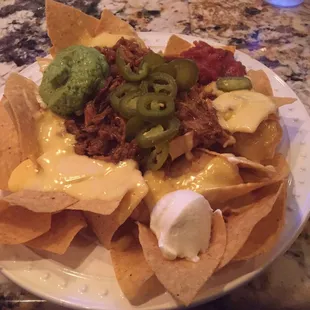 Pulled pork loaded nachos with cheese, sour cream, guacamole, pulled pork, and jalapeños.  Tres delicious!!!