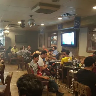 People getting ready for one of the weekly parties, with a card game finishing up on the side.