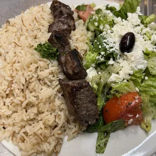 a plate of food with rice, meat, and vegetables