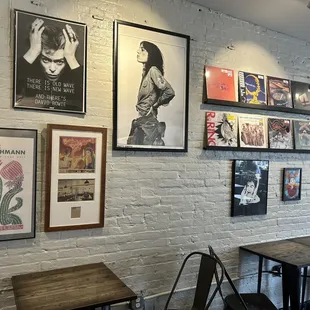 a white brick wall with posters on it