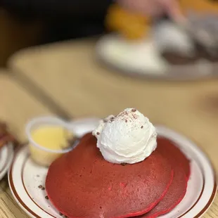 a red velvet pancake with whipped cream on top