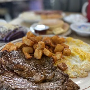 steak, eggs, potatoes, and hash browns