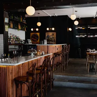 a view of a bar with stools and tables