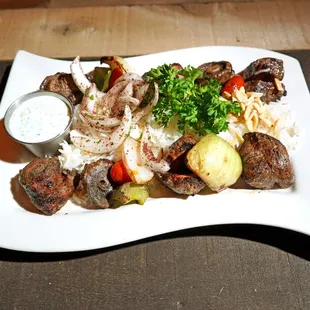 LAHM MECHWI
Tender Cubes of lamb, specially marinated &amp; grilled with onions, tomatoes, peppers &amp; mushrooms.