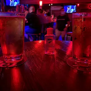 two glasses of beer on a bar