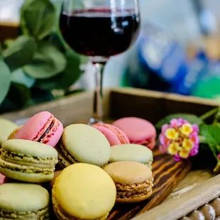 a tray of macarons and a glass of wine