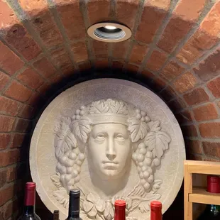 a bust of a woman surrounded by wine bottles