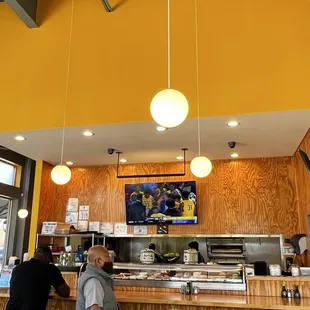 a man standing at a counter in a restaurant