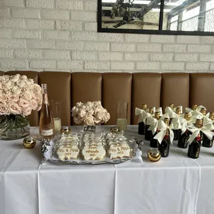 a banquet table with champagne, cookies, and champagne flutes