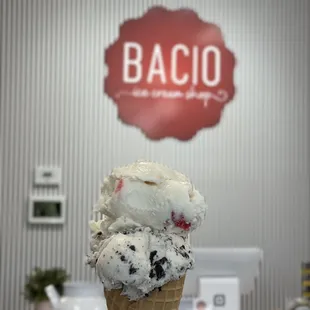 Waffle cone with 1 scoop of cookies and cream and strawberry cheesecake