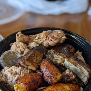 Jerk chicken and pork plate comes with fried plantains and rice and beans
