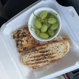 a sandwich, grapes, and salad