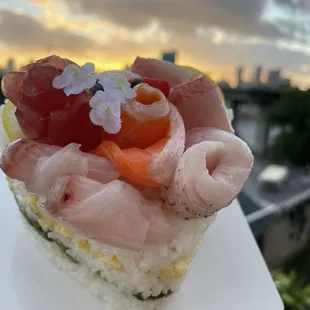 a hand holding a piece of sushi