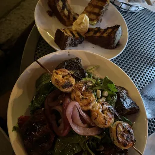 Steak tips salad with shrimp. And a side of corn bread