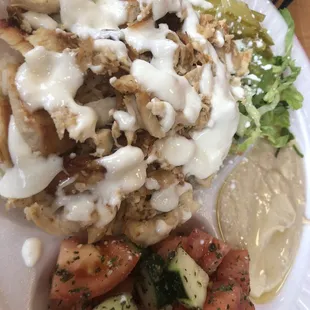 Chicken shawarma over rice plate with two sides: hummus and salad