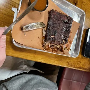 a tray of ribs and sauce