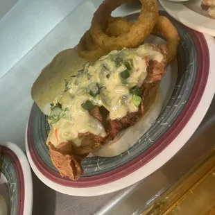 Chicken sandwich smothered in green chile cheese.