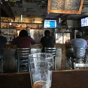 a glass of beer sitting on a bar