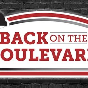 a brick wall with a sign that says back on the boulevard