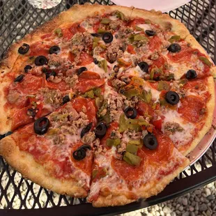 a pizza with olives and ground meat