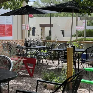 tables and chairs under umbrellas