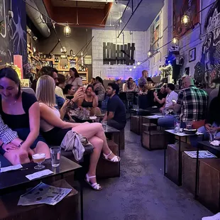 a group of people sitting at tables in a bar