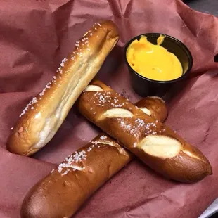 two pretzels and a bowl of mustard