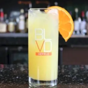 a glass of orange juice with a slice of orange