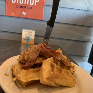 Chicken and waffles topped with bacon