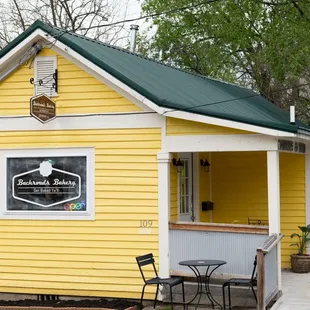 a yellow building with a green roof