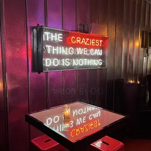 a neon sign that reads the craziest thing we can do is nothing