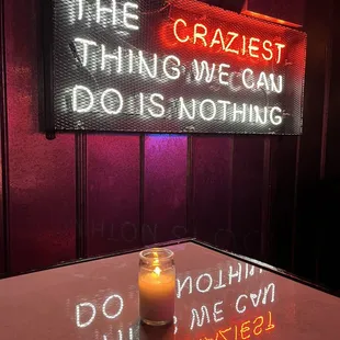 a lit candle and neon sign