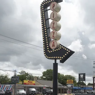 a black car parked in front of a pizza parlor