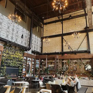 Interior of Backstory Coffee and their iconic fireplace with their plant wall