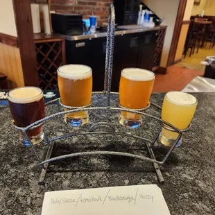 five glasses of beer on a counter