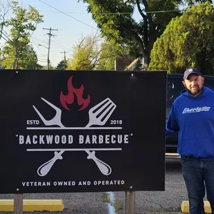 a man standing in front of a sign