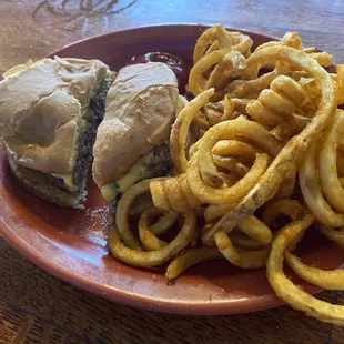 Burger on regular bun, plain and dry with curly fries.