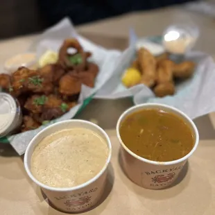 two cups of soup and a plate of fried chicken