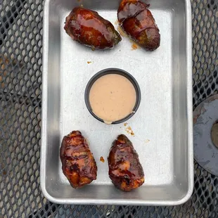 chicken wings in a pan with dipping sauce
