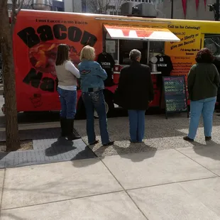 a group of people standing in front of a food truck