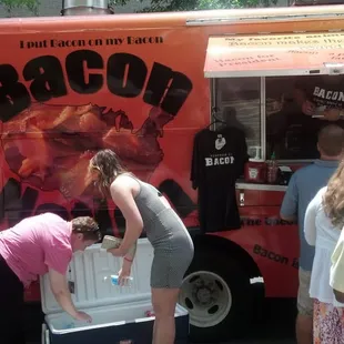 a group of people standing around a food truck