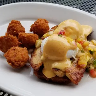 Costa Rica Benedict with smoked pork belly, poached eggs, pineapple salsa, and chipotle hollandaise on jalapeño cornbread + bacon tots