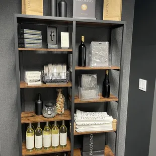 a shelf of wine bottles and wine glasses