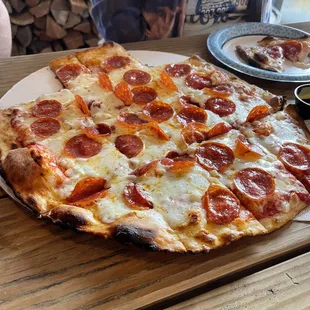 a pepperoni pizza on a cutting board